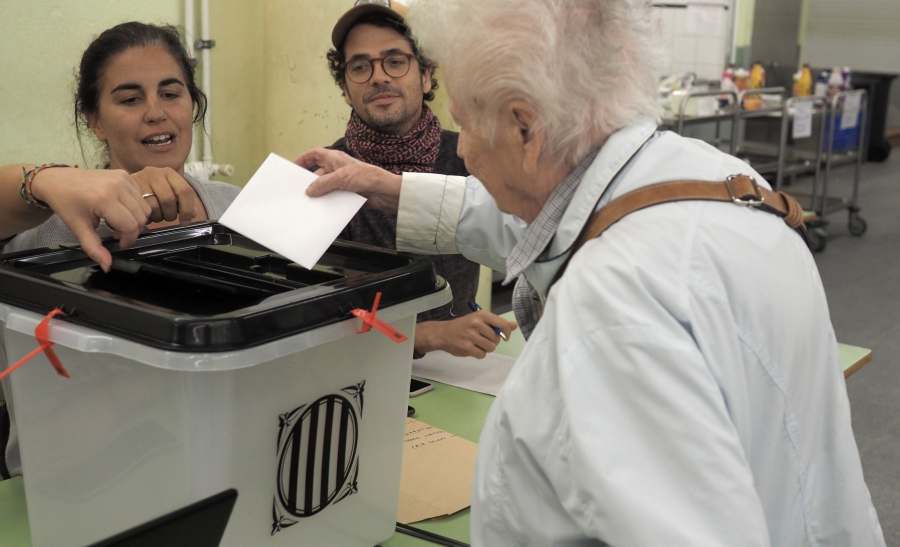 A voter partakes in a risky endeavor: casting a ballot in Catalonia's outlawed referendum for independence from Spain. A voter partakes in a risky endeavor: casting a ballot in Catalonia's outlawed referendum for independence from Spain.
